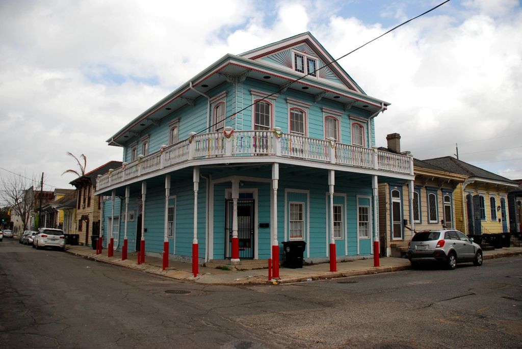 A cyan wooden house in the street of New Orleans.
