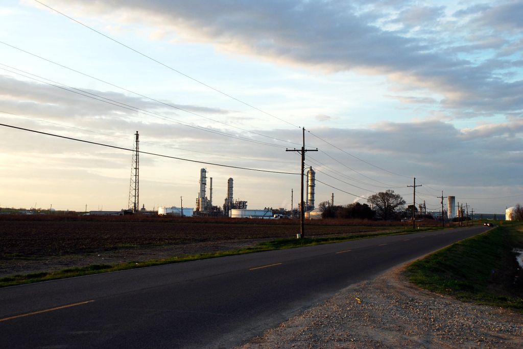 A road in Louisiana with some petroleum industry in the background.