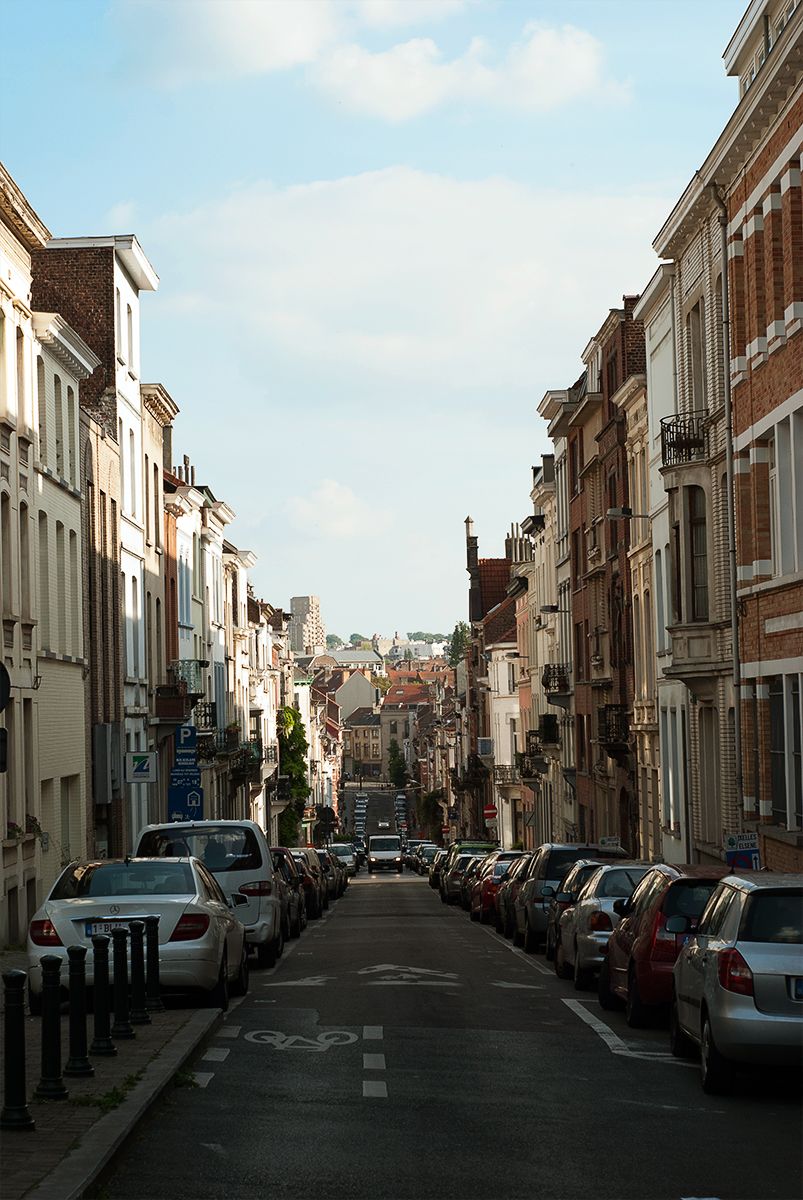 A sloping street of Ixelles (Bruxelles) with car on both side.
