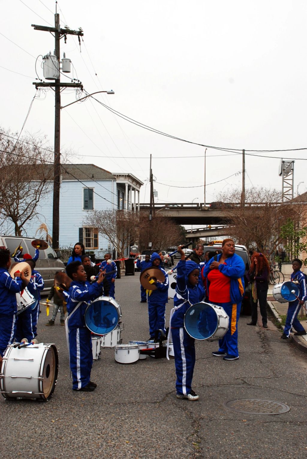 A group of kid playing member of a school brass band preparing to walk for a parade in the street of New Orleans.